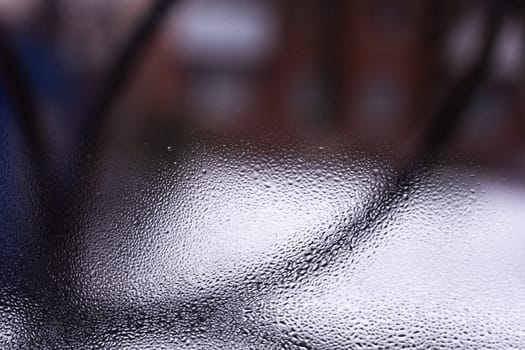 Water drops on glass window close up with blurred background. Drops in macro. Condensate on window closeup. Wet air.