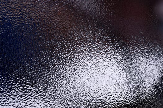 Water drops on glass window close up with blurred background. Drops in macro. Condensate on window closeup. Wet air.
