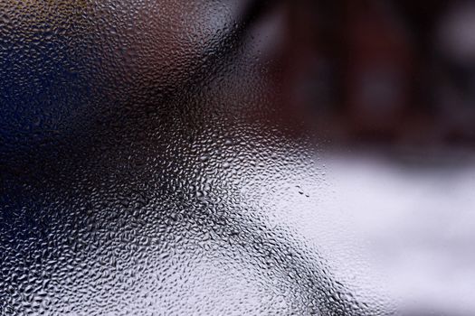 Water drops on glass window close up with blurred background. Drops in macro. Condensate on window closeup. Wet air.