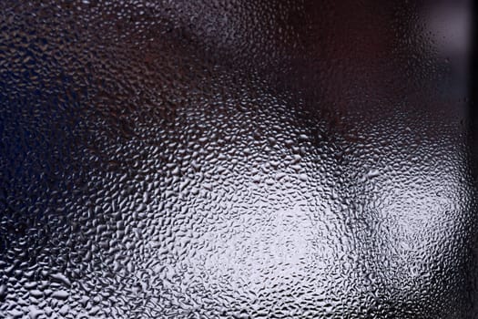 Water drops on glass window close up with blurred background. Drops in macro. Condensate on window closeup. Wet air.