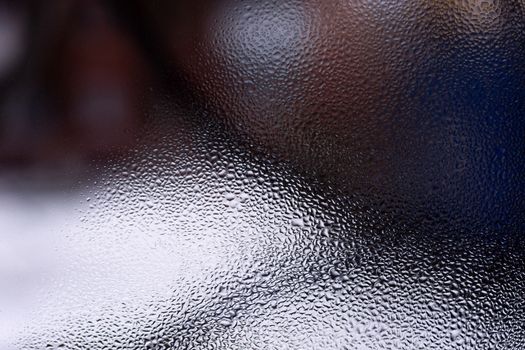 Water drops on glass window close up with blurred background. Drops in macro. Condensate on window closeup. Wet air.