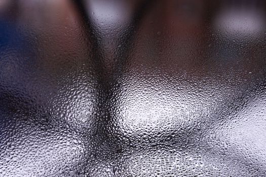 Water drops on glass window close up with blurred background. Drops in macro. Condensate on window closeup. Wet air.