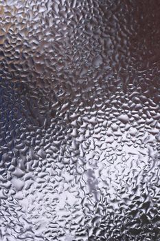 Water drops on glass window close up with blurred background. Drops in macro. Condensate on window closeup. Wet air.