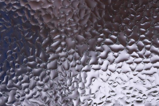 Water drops on glass window close up with blurred background. Drops in macro. Condensate on window closeup. Wet air.