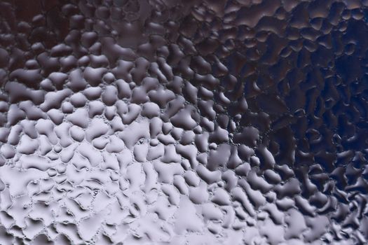 Water drops on glass window close up with blurred background. Drops in macro. Condensate on window closeup. Wet air.