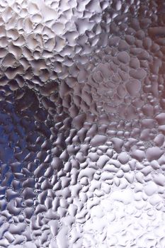 Water drops on glass window close up with blurred background. Drops in macro. Condensate on window closeup. Wet air.