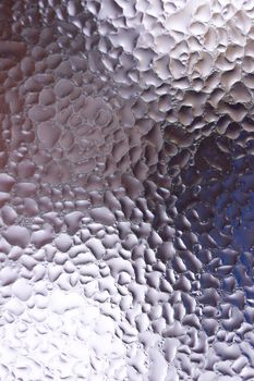 Water drops on glass window close up with blurred background. Drops in macro. Condensate on window closeup. Wet air.