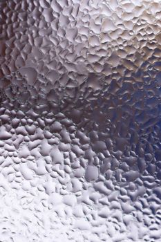 Water drops on glass window close up with blurred background. Drops in macro. Condensate on window closeup. Wet air.