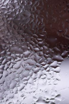 Water drops on glass window close up with blurred background. Drops in macro. Condensate on window closeup. Wet air.