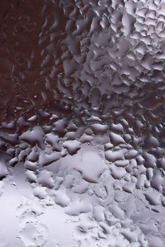 Water drops on glass window close up with blurred background. Drops in macro. Condensate on window closeup. Wet air.