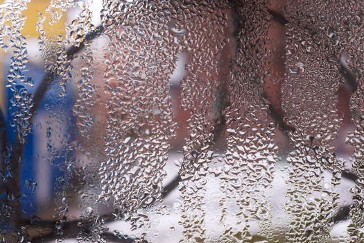 Water drops on glass window close up with blurred background. Drops in macro. Condensate on window closeup. Wet air.
