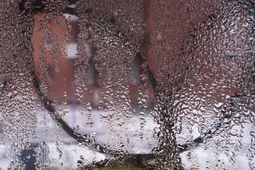 Water drops on glass window close up with blurred background. Drops in macro. Condensate on window closeup. Wet air.