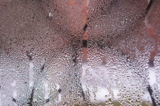 Water drops on glass window close up with blurred background. Drops in macro. Condensate on window closeup. Wet air.
