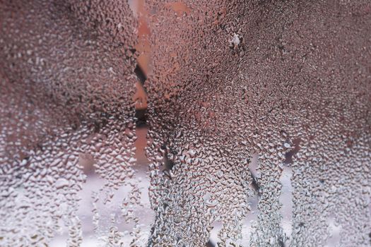 Water drops on glass window close up with blurred background. Drops in macro. Condensate on window closeup. Wet air.