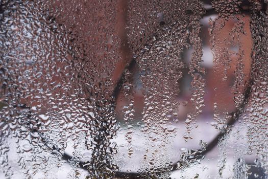 Water drops on glass window close up with blurred background. Drops in macro. Condensate on window closeup. Wet air.