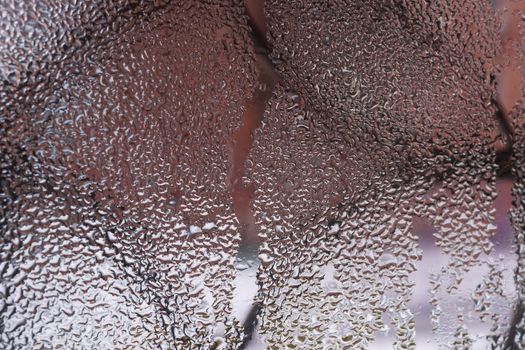 Water drops on glass window close up with blurred background. Drops in macro. Condensate on window closeup. Wet air.
