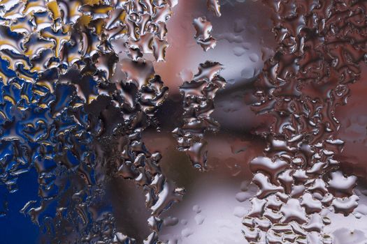 Water drops on glass window close up with blurred background. Drops in macro. Condensate on window closeup. Wet air.