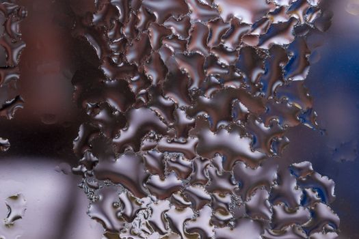 Water drops on glass window close up with blurred background. Drops in macro. Condensate on window closeup. Wet air.