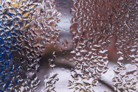 Water drops on glass window close up with blurred background. Drops in macro. Condensate on window closeup. Wet air.