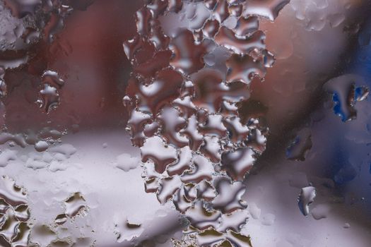 Water drops on glass window close up with blurred background. Drops in macro. Condensate on window closeup. Wet air.