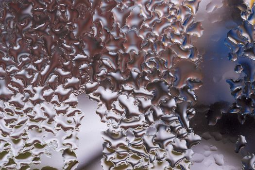 Water drops on glass window close up with blurred background. Drops in macro. Condensate on window closeup. Wet air.