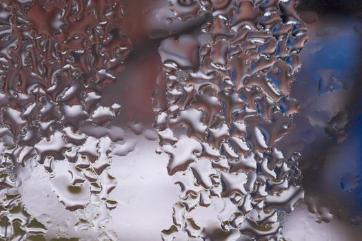 Water drops on glass window close up with blurred background. Drops in macro. Condensate on window closeup. Wet air.