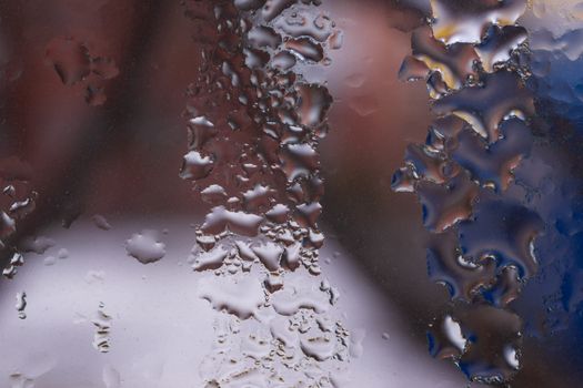 Water drops on glass window close up with blurred background. Drops in macro. Condensate on window closeup. Wet air.