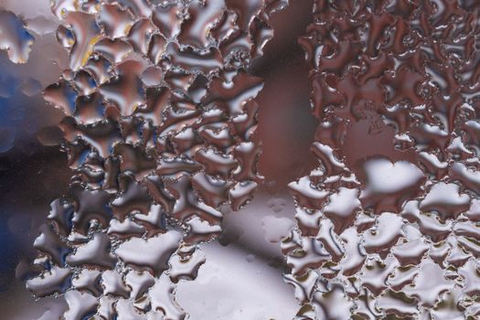 Water drops on glass window close up with blurred background. Drops in macro. Condensate on window closeup. Wet air.