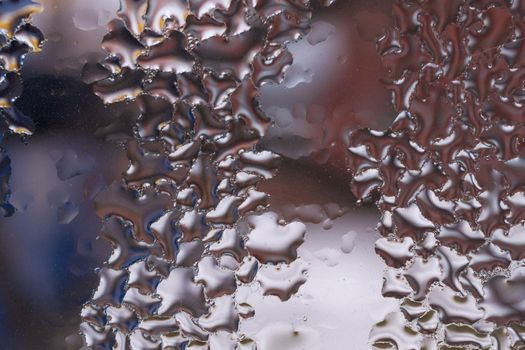 Water drops on glass window close up with blurred background. Drops in macro. Condensate on window closeup. Wet air.