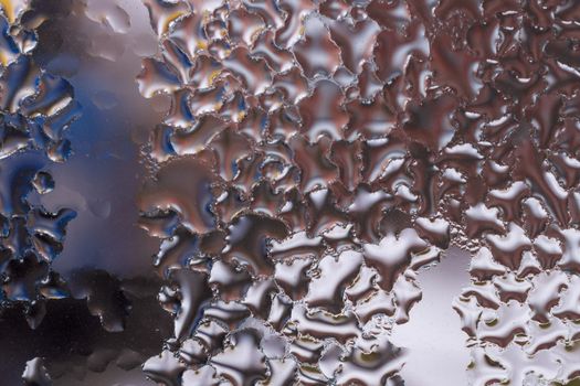 Water drops on glass window close up with blurred background. Drops in macro. Condensate on window closeup. Wet air.