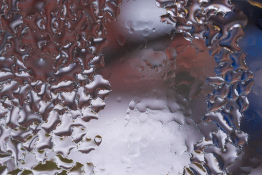 Water drops on glass window close up with blurred background. Drops in macro. Condensate on window closeup. Wet air.