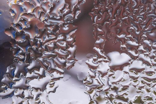 Water drops on glass window close up with blurred background. Drops in macro. Condensate on window closeup. Wet air.