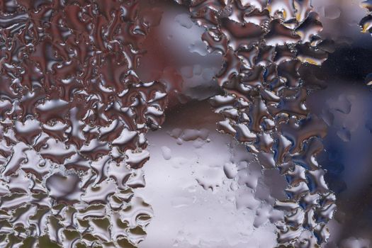 Water drops on glass window close up with blurred background. Drops in macro. Condensate on window closeup. Wet air.