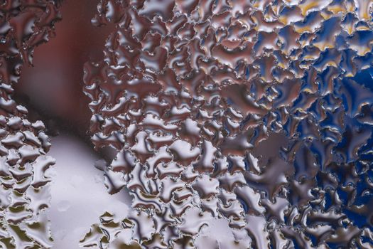 Water drops on glass window close up with blurred background. Drops in macro. Condensate on window closeup. Wet air.