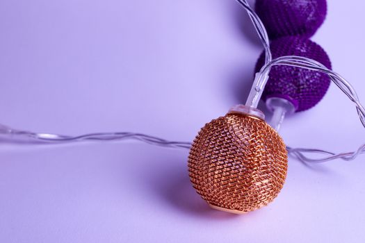 Battery garland with metallic grid balls on white background. Closeup view with blurred background.