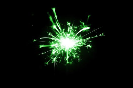Low light photo of bengali fire isolated on black background with green toning. A lot of light and sparks. Underexposed photo.