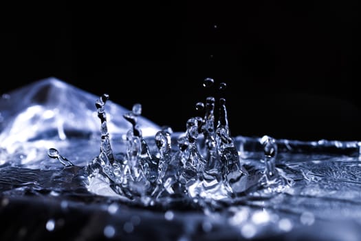 Water drops splashing on acoustic membrane. A lot of drops in air. High frequency of sound waves. Water cloud small drops. Frozen time shot.