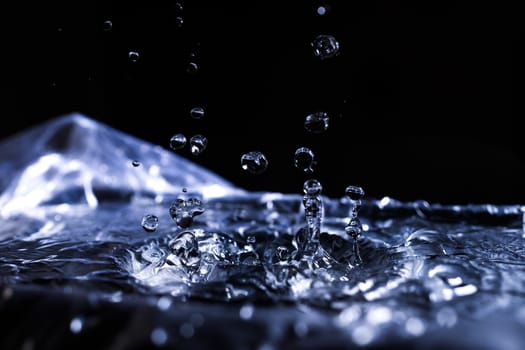 Water drops splashing on acoustic membrane. A lot of drops in air. High frequency of sound waves. Water cloud small drops. Frozen time shot.