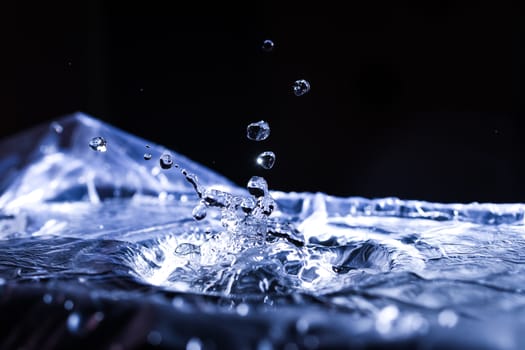 Water drops splashing on acoustic membrane. A lot of drops in air. High frequency of sound waves. Water cloud small drops. Frozen time shot.
