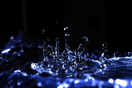 Water drops splashing on acoustic membrane. A lot of drops in air. High frequency of sound waves. Water cloud small drops. Frozen time shot.