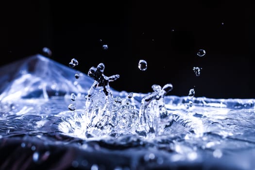 Water drops splashing on acoustic membrane. A lot of drops in air. High frequency of sound waves. Water cloud small drops. Frozen time shot. 