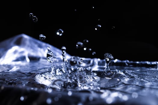 Water drops splashing on acoustic membrane. A lot of drops in air. High frequency of sound waves. Water cloud small drops. Frozen time shot.