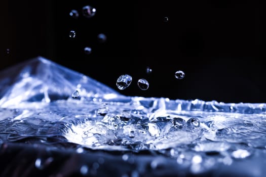Water drops splashing on acoustic membrane. A lot of drops in air. High frequency of sound waves. Water cloud small drops. Frozen time shot. 