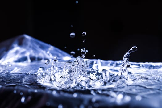 Water drops splashing on acoustic membrane. A lot of drops in air. High frequency of sound waves. Water cloud small drops. Frozen time shot. 