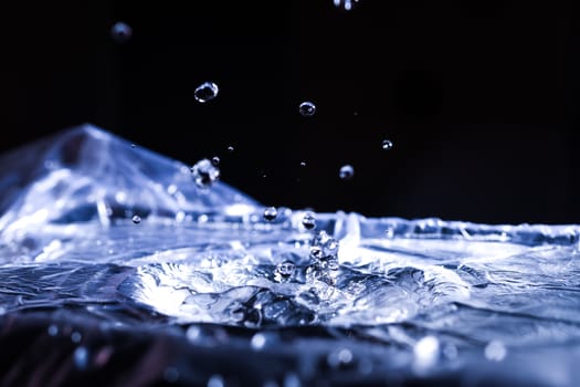 Water drops splashing on acoustic membrane. A lot of drops in air. High frequency of sound waves. Water cloud small drops. Frozen time shot. 