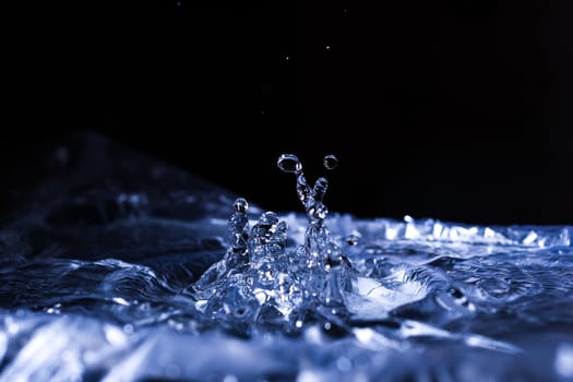Water drops splashing on acoustic membrane. A lot of drops in air. High frequency of sound waves. Water cloud small drops. Frozen time shot. 