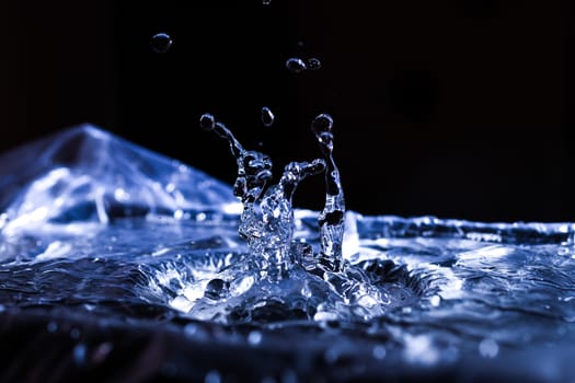 Water drops splashing on acoustic membrane. A lot of drops in air. High frequency of sound waves. Water cloud small drops. Frozen time shot. 