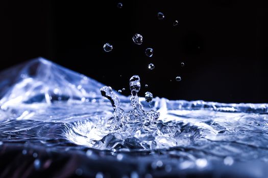 Water drops splashing on acoustic membrane. A lot of drops in air. High frequency of sound waves. Water cloud small drops. Frozen time shot. 