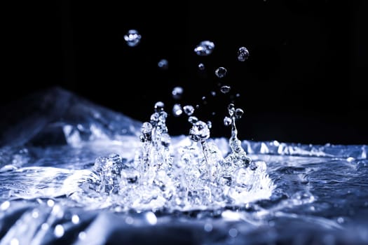 Water drops splashing on acoustic membrane. A lot of drops in air. High frequency of sound waves. Water cloud small drops. Frozen time shot. 