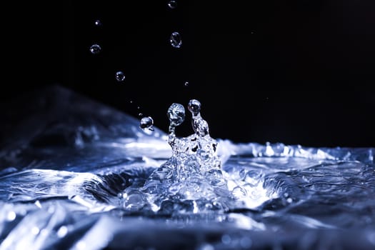 Water drops splashing on acoustic membrane. A lot of drops in air. High frequency of sound waves. Water cloud small drops. Frozen time shot. 